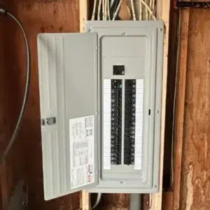 electrical safety inspections in Lynnwood electrician examining open panel with voltage tester
