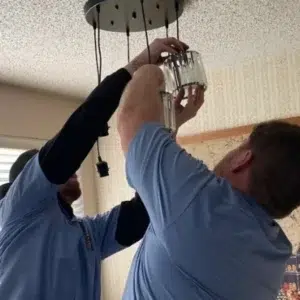 lighting specialists in Everett electrician installing recessed lighting fixture in ceiling