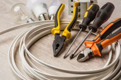 A set of tools electrician, a coil of wire and equipment on a white background