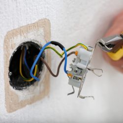 Hands of electrician installing socket, closeup